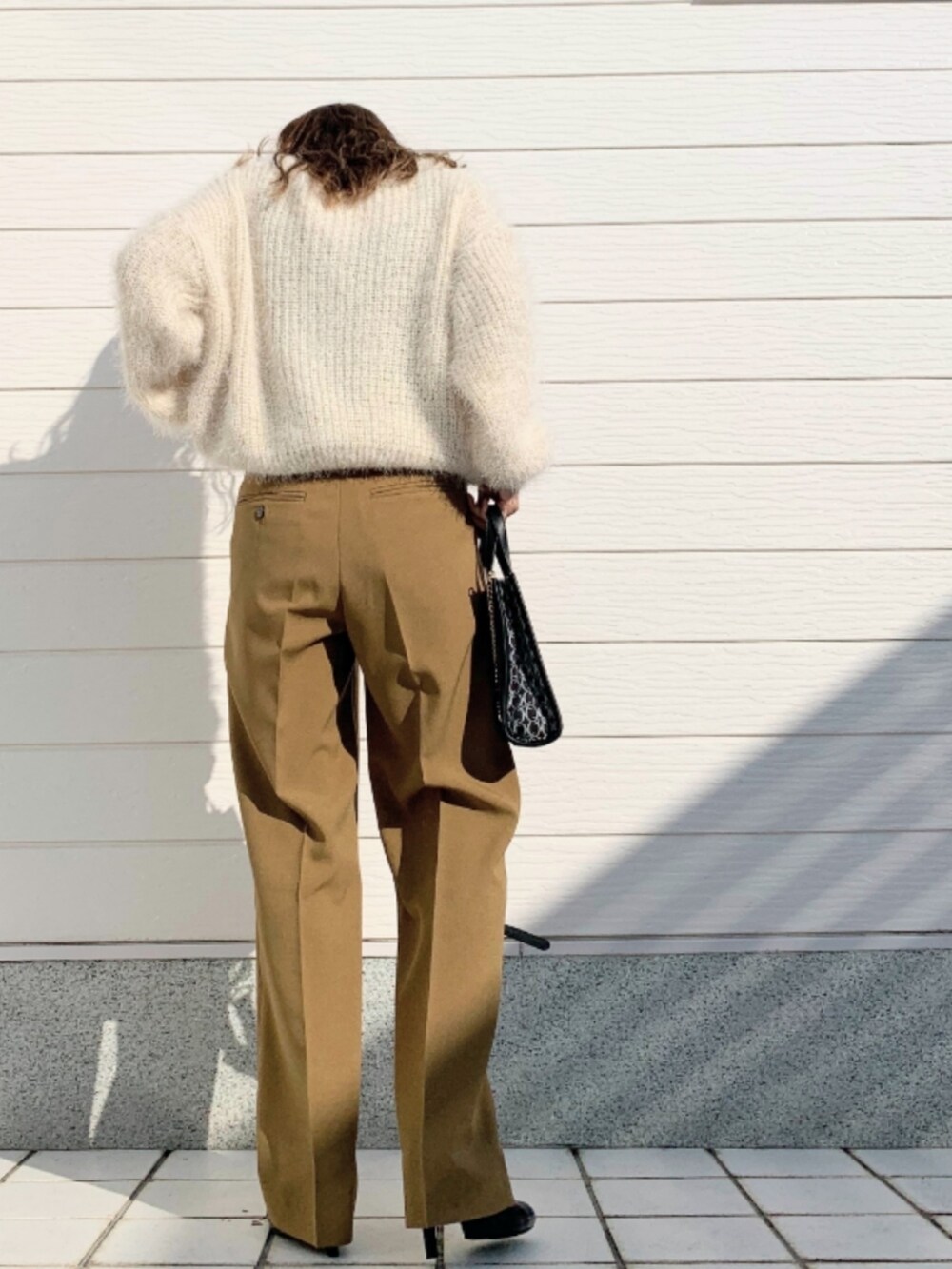 ブラック系のショルダーバッグ、イエロー系のその他パンツ、ホワイト系のニット/セーターを着用したレディースの秋コーディネートの3枚目の写真