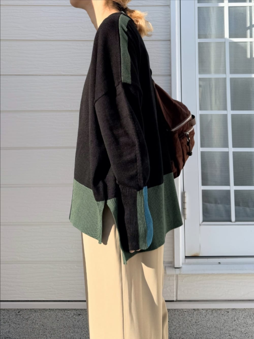 ベージュ系のその他パンツ、ブラック系のニット/セーター、ブラウン系のバックパック/リュックを着用したレディースの秋コーディネートの3枚目の写真