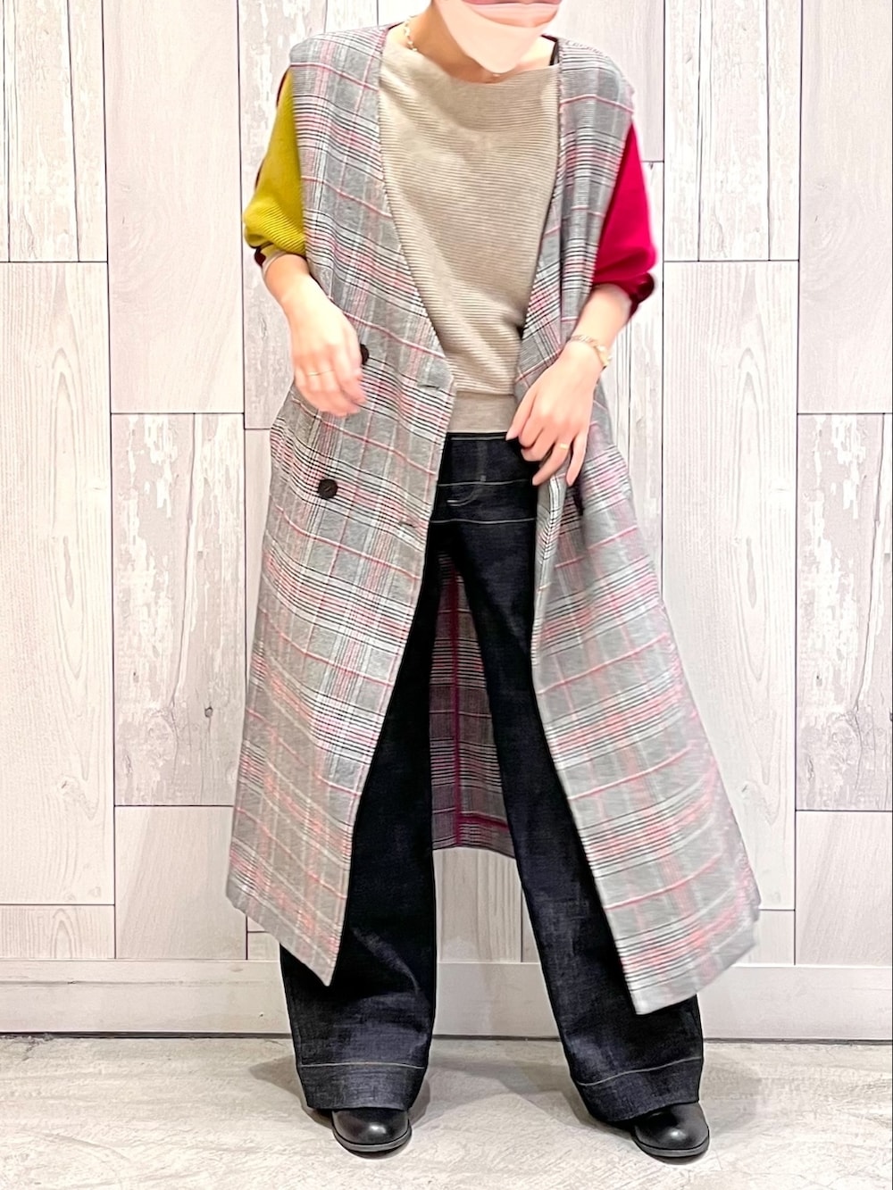 ブルー系のデニムパンツ、レッド系のニット/セーター、ブラック系のトレンチコートを着用したレディースの秋コーディネートの2枚目の写真