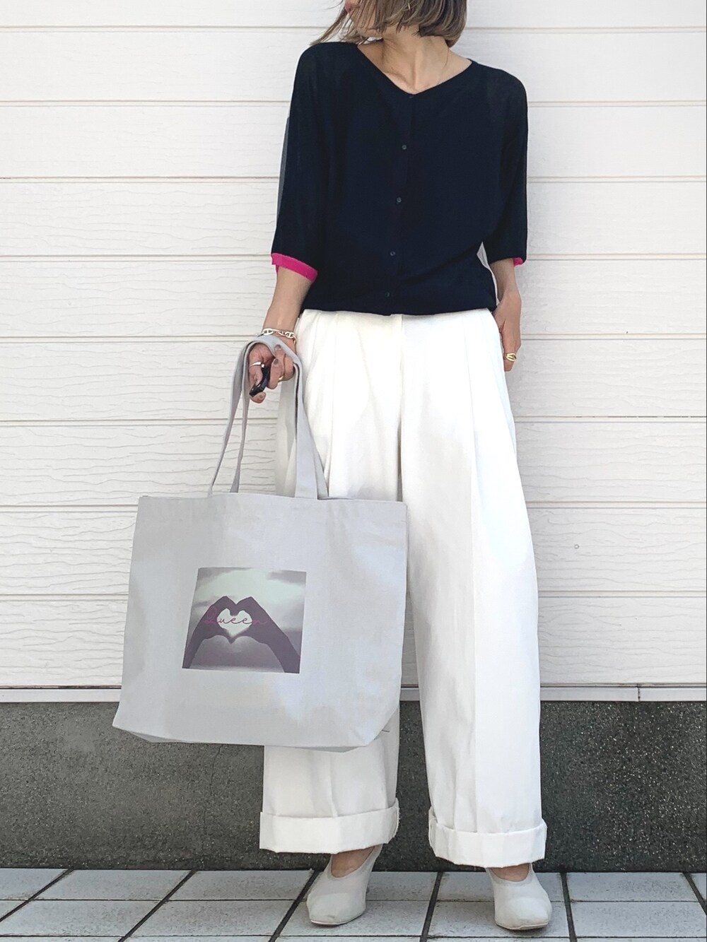 グレー系のトートバッグ、ホワイト系のその他パンツ、ブラック系のニット/セーターを着用したレディースの春コーディネートの2枚目の写真