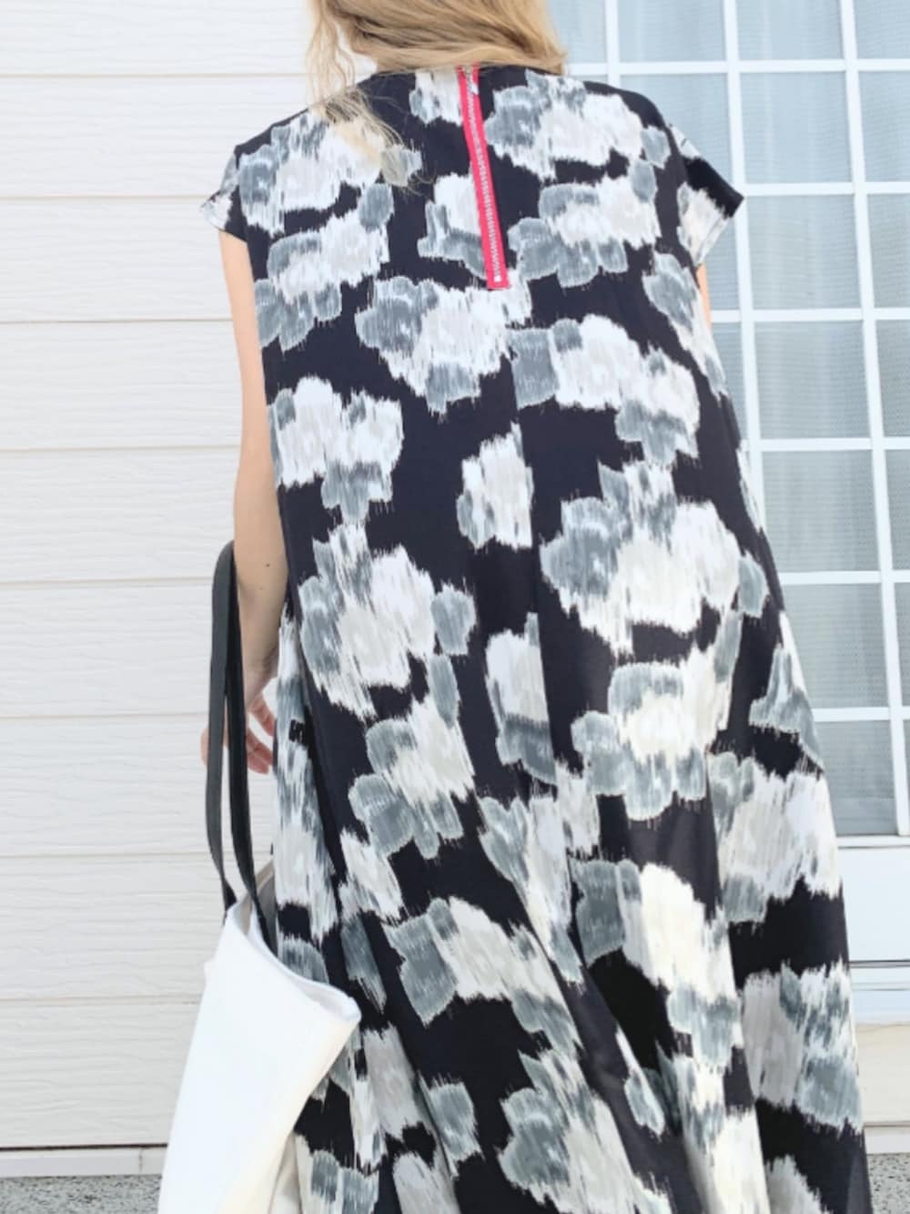 ブラック系のワンピース、ホワイト系のスニーカー、ホワイト系のトートバッグを着用したレディースの春コーディネートの5枚目の写真