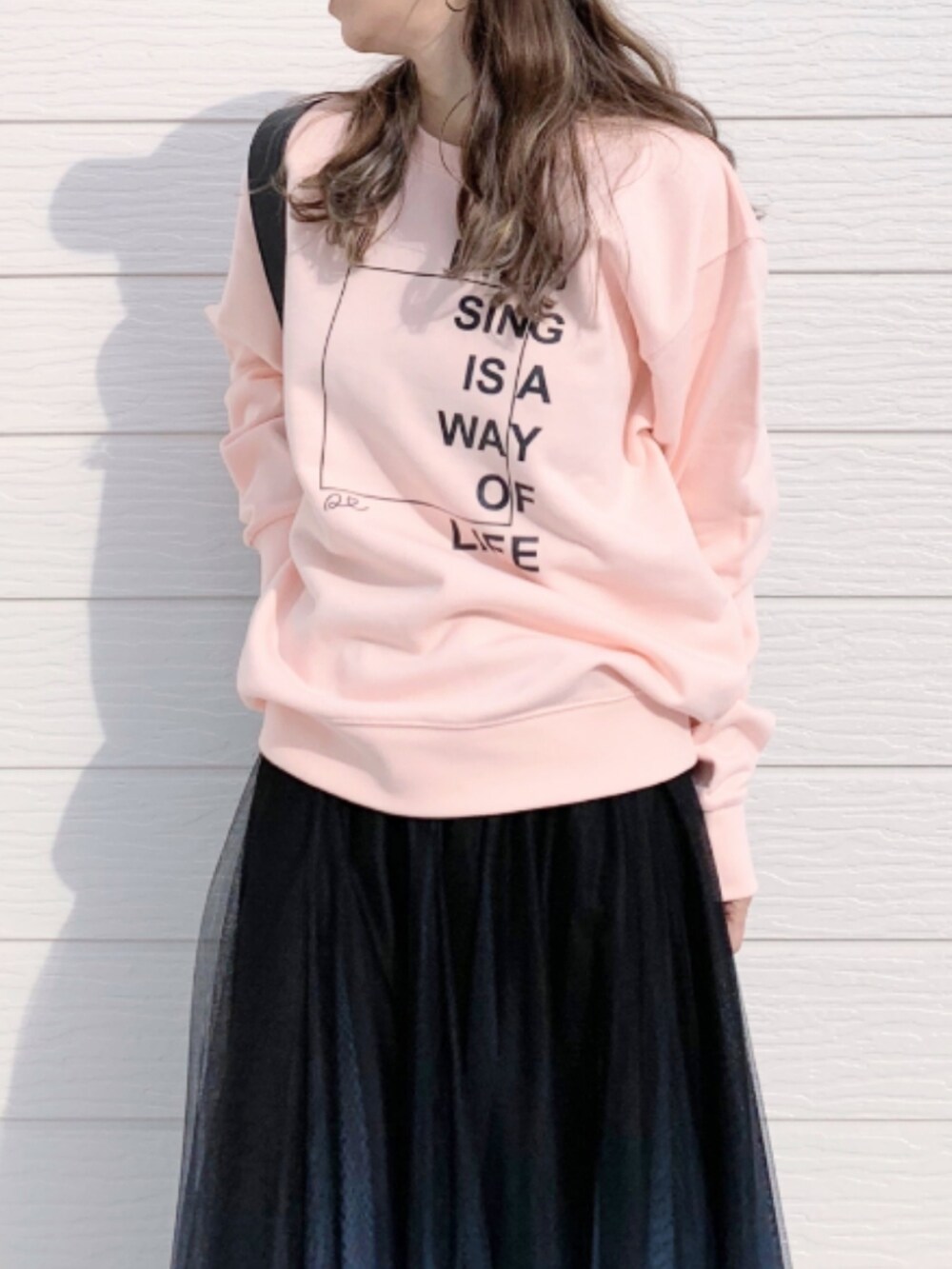 ブラック系のスカート、ホワイト系のスニーカー、ピンク系のスウェットを着用したレディースの春コーディネートの3枚目の写真