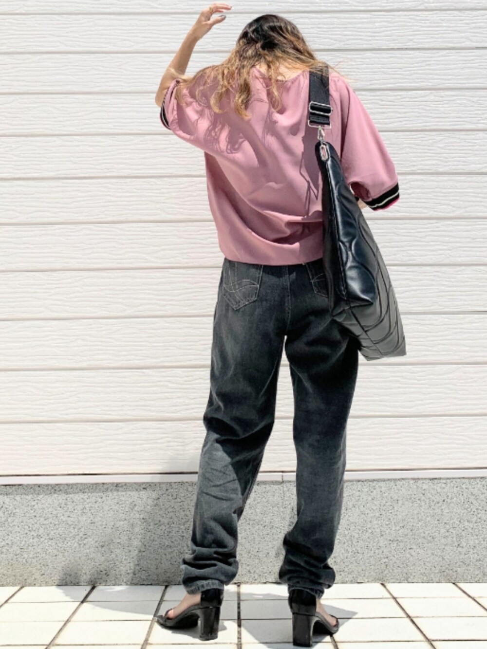 グレー系のデニムパンツ、ブラック系のハンドバッグ、ピンク系のシャツ/ブラウスを着用したレディースの夏コーディネートの2枚目の写真