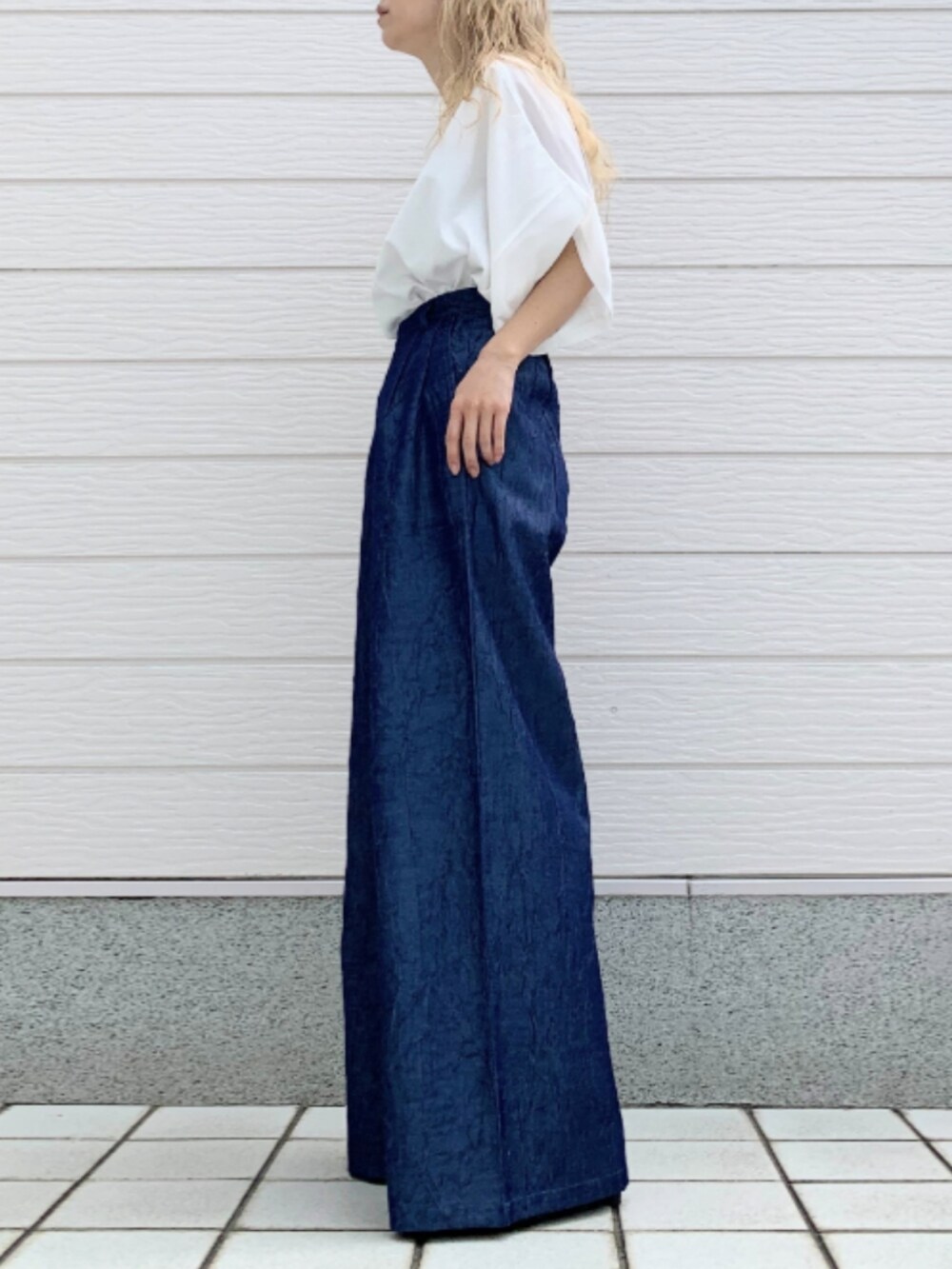 ホワイト系のTシャツ/カットソー、ブラック系のかごバッグ、ブルー系のデニムパンツを着用したレディースの春コーディネートの2枚目の写真