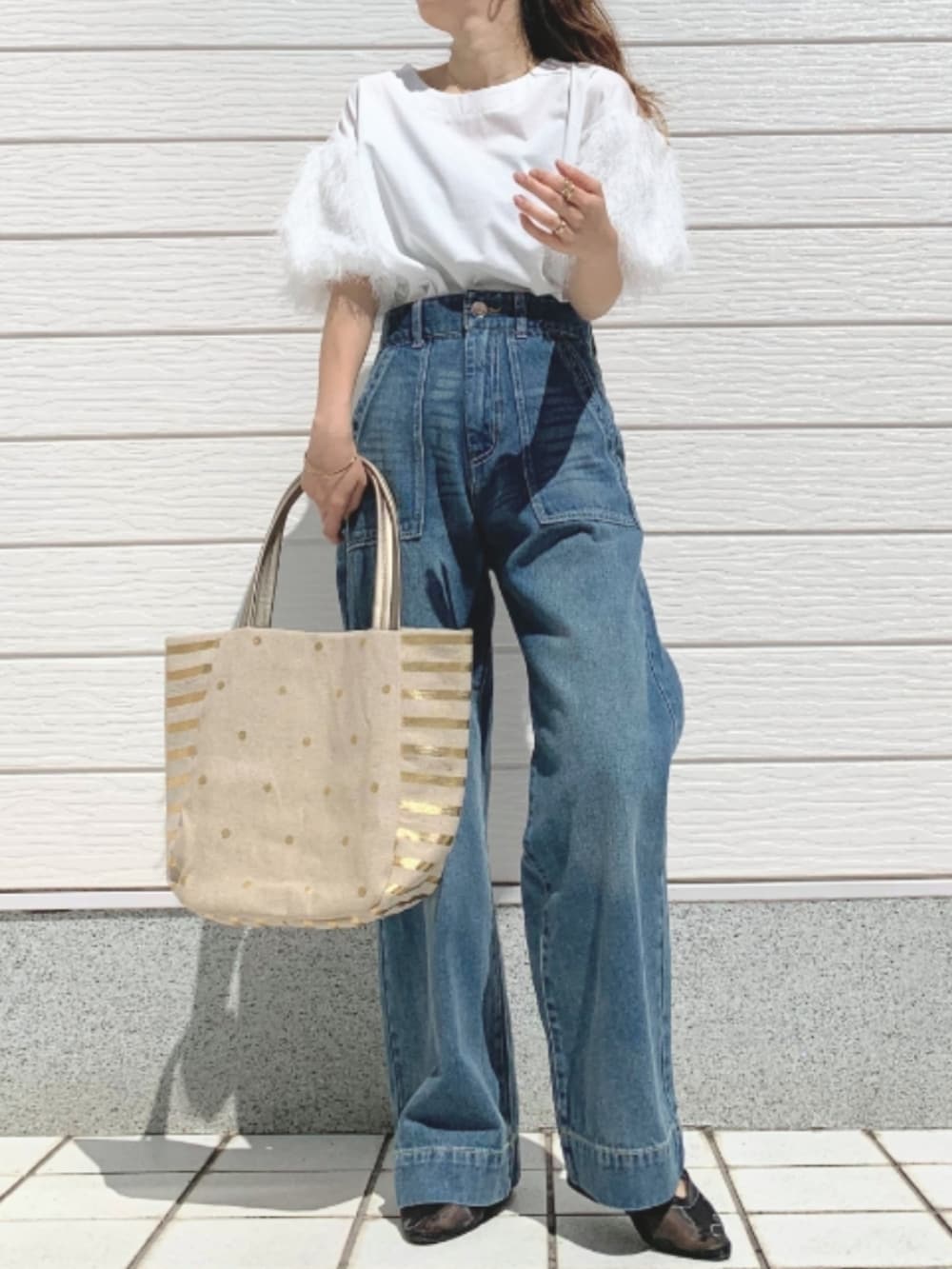 ホワイト系のTシャツ/カットソー、ゴールド系のトートバッグ、ブラック系のパンプスを着用したレディースの春コーディネートの2枚目の写真