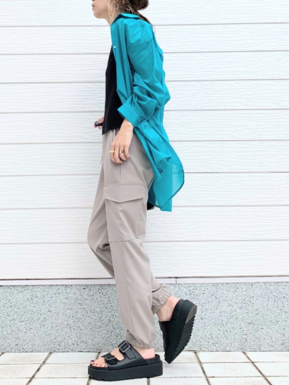 ブラック系のサンダル、ベージュ系のカーゴパンツ、ブラック系のショルダーバッグを着用したレディースの春コーディネートの3枚目の写真