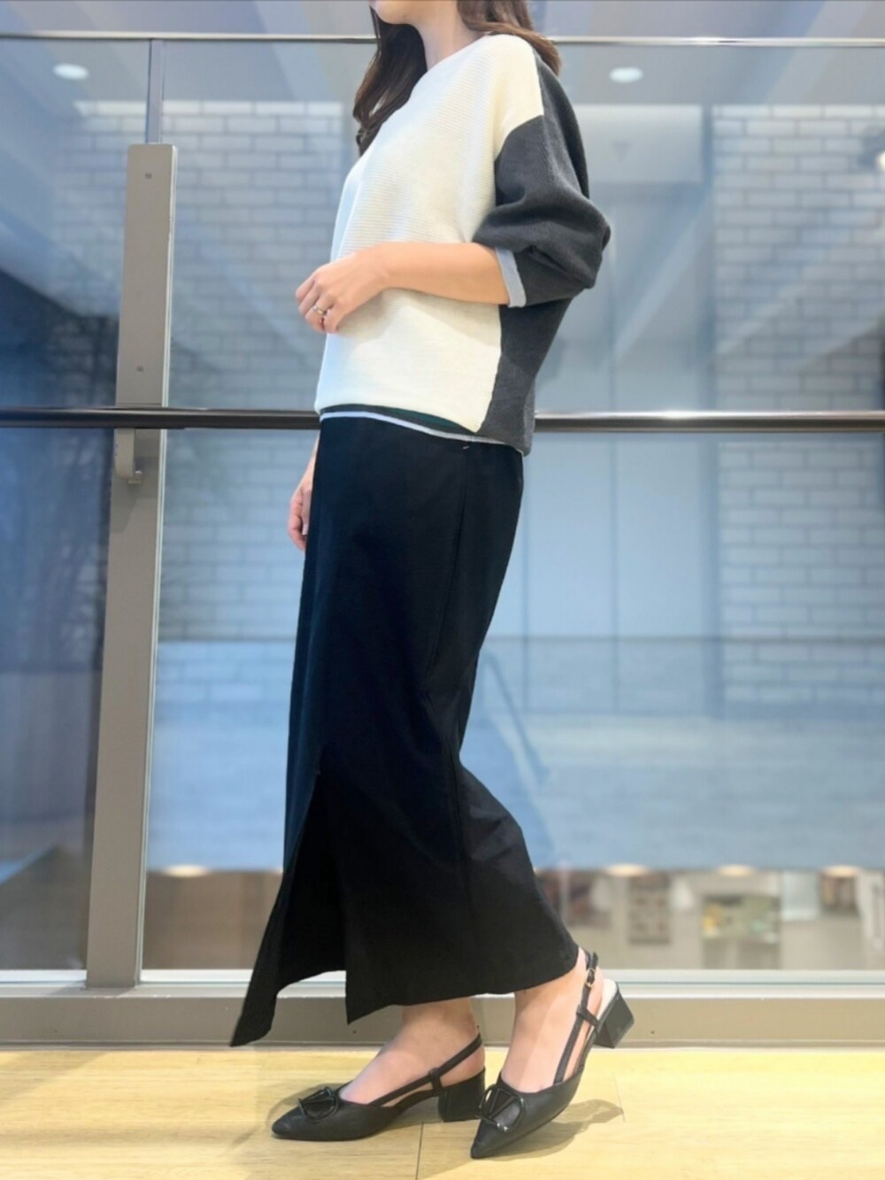 ホワイト系のニット/セーター、ブラック系のスカートを着用したレディースの秋コーディネートの3枚目の写真
