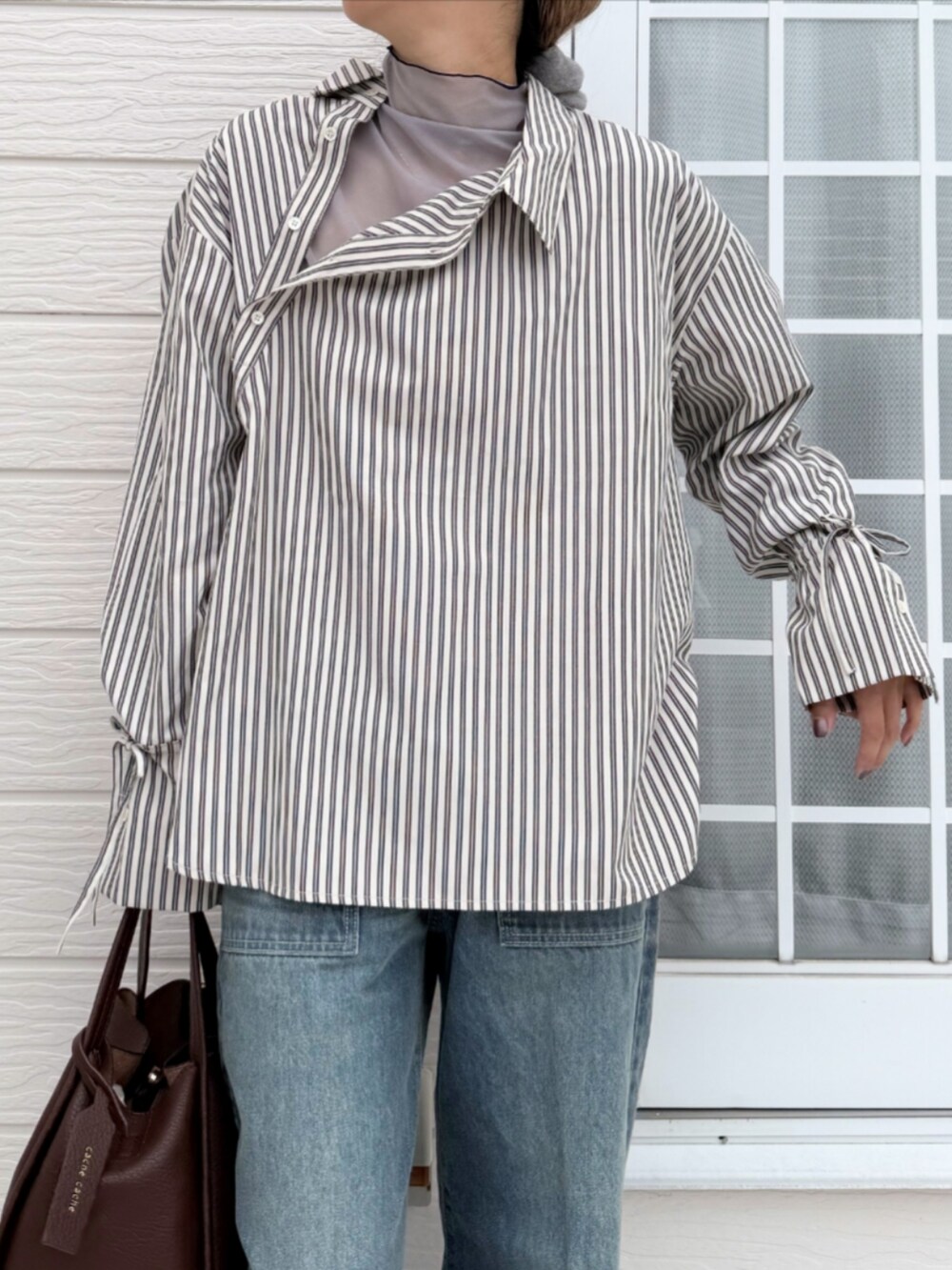 ブラウン系のハンドバッグ、ブラック系のシャツ/ブラウス、グレー系のTシャツ/カットソーを着用したレディースの秋コーディネートの4枚目の写真