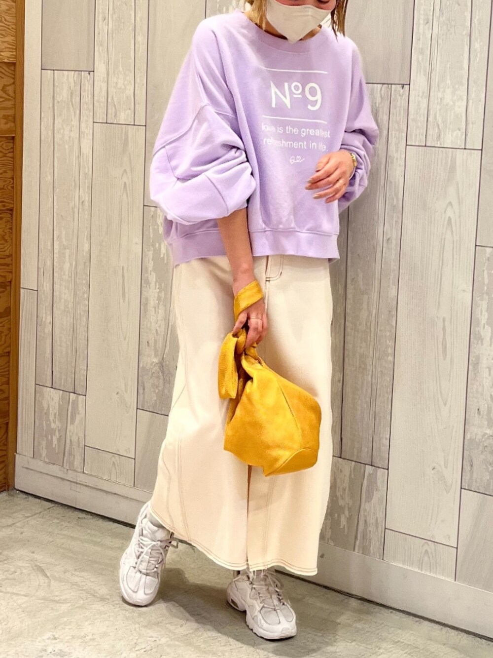 イエロー系のショルダーバッグ、パープル系のスウェット、ホワイト系のスカートを着用したレディースの春コーディネートの2枚目の写真