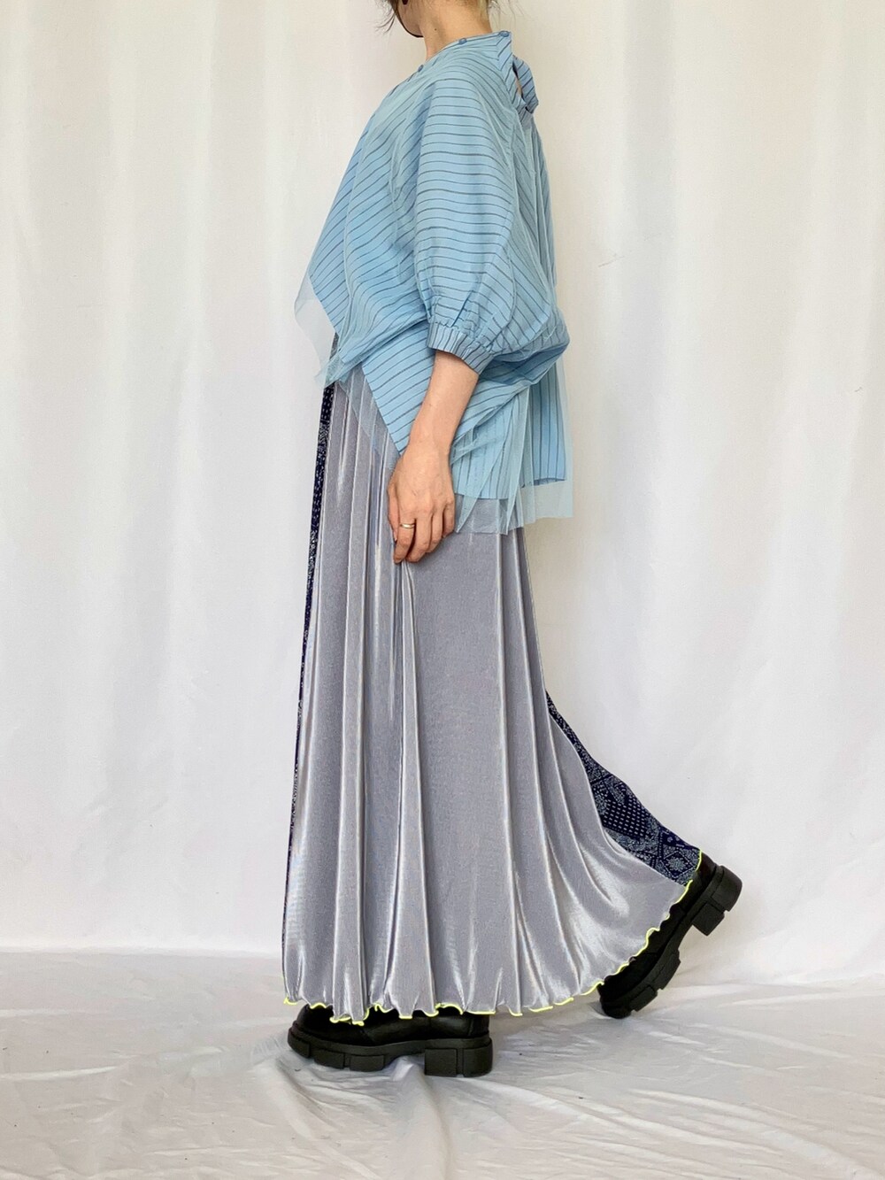 ブルー系のシャツ/ブラウス、ブルー系のスカート、ブラック系のブーツを着用したレディースの夏コーディネートの2枚目の写真