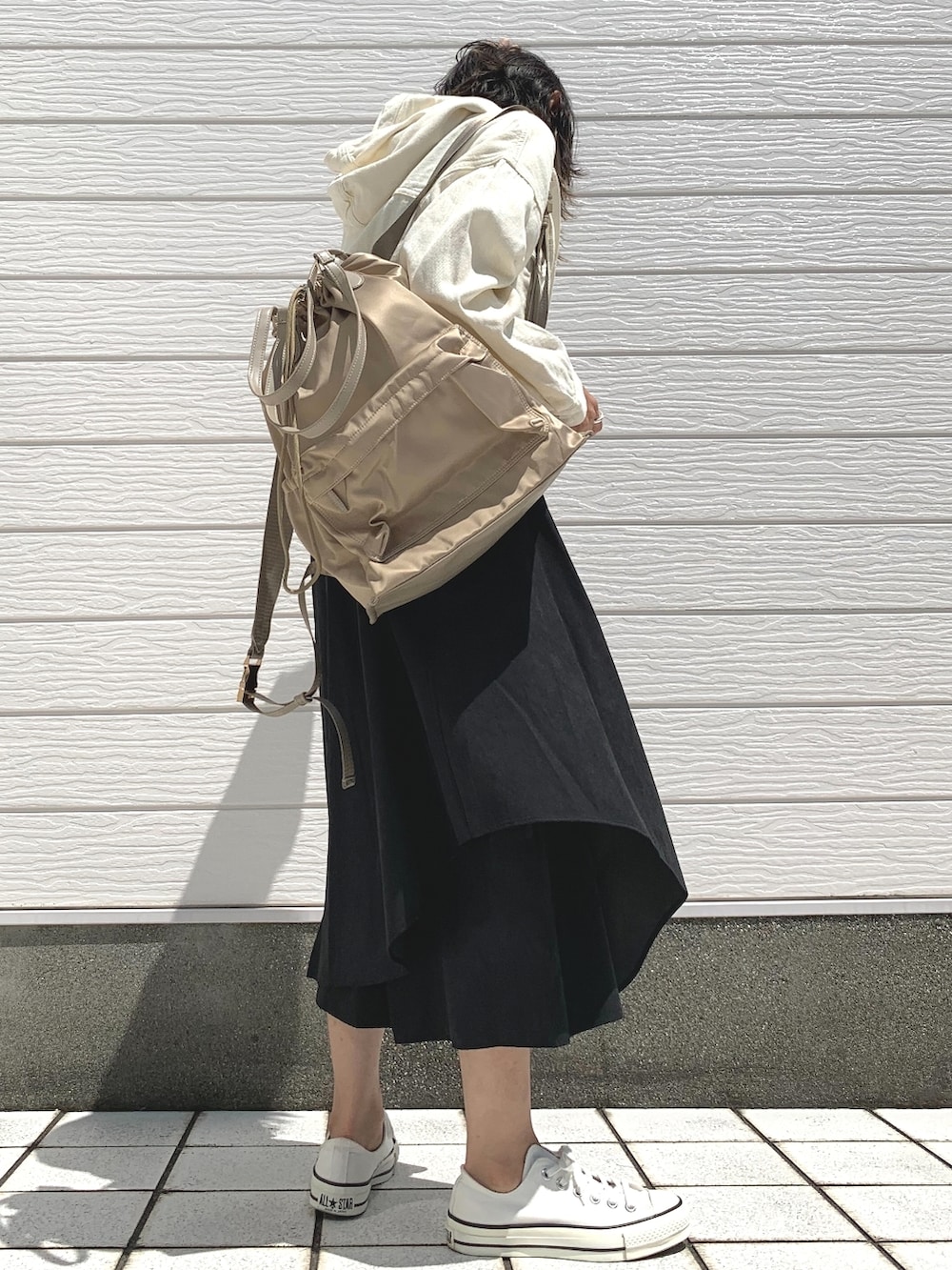 ベージュ系のバックパック/リュック、ブラック系のその他パンツ、ホワイト系のスニーカーを着用したレディースの夏コーディネートの2枚目の写真