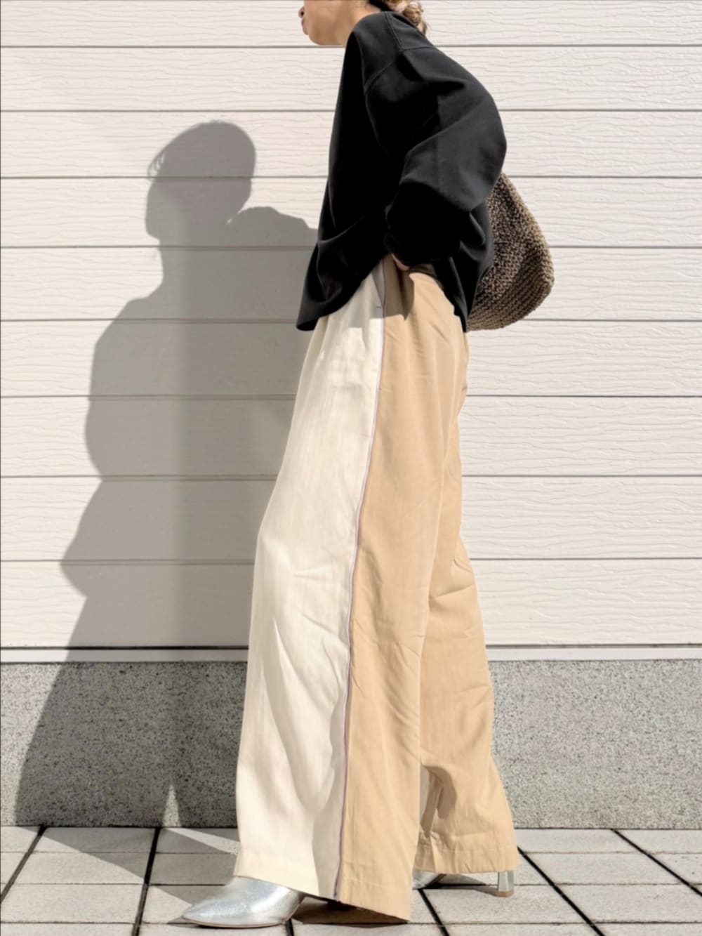 グレー系のTシャツ/カットソー、ベージュ系のトートバッグ、ホワイト系のその他パンツを着用したレディースの冬コーディネートの3枚目の写真