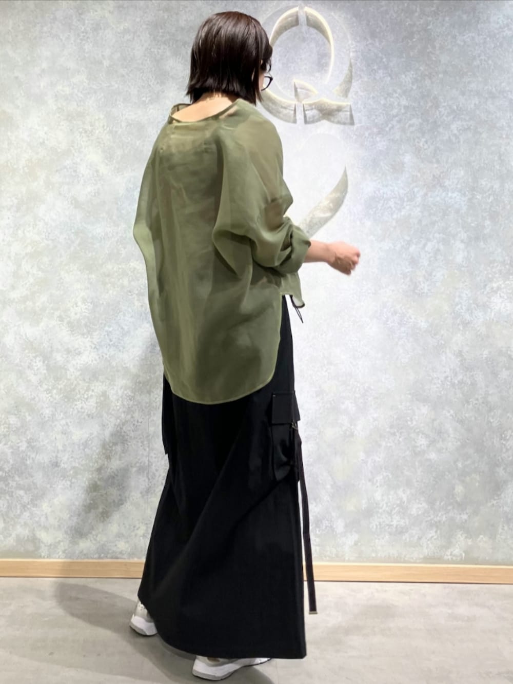 ブラック系のジャンパースカート、グリーン系のシャツ/ブラウス、レッド系のタンクトップを着用したレディースの秋コーディネートの3枚目の写真