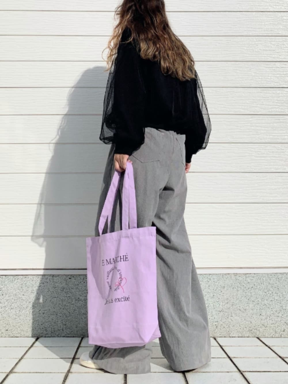 パープル系のトートバッグ、ホワイト系のスニーカー、グレー系のその他パンツを着用したレディースの秋コーディネートの3枚目の写真