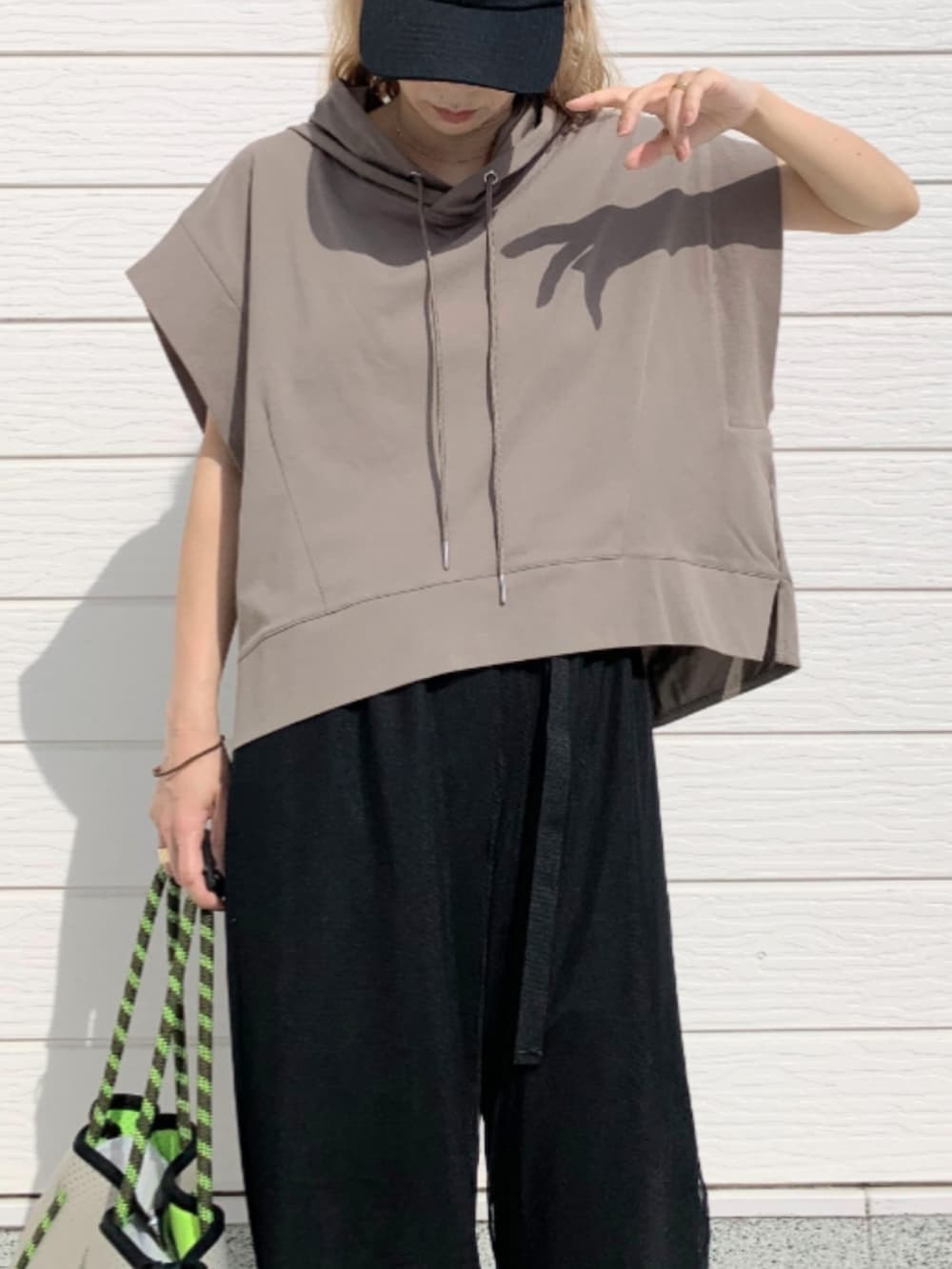 ブラック系のその他パンツ、グレー系のトートバッグ、グリーン系のパーカーを着用したレディースの春コーディネートの4枚目の写真