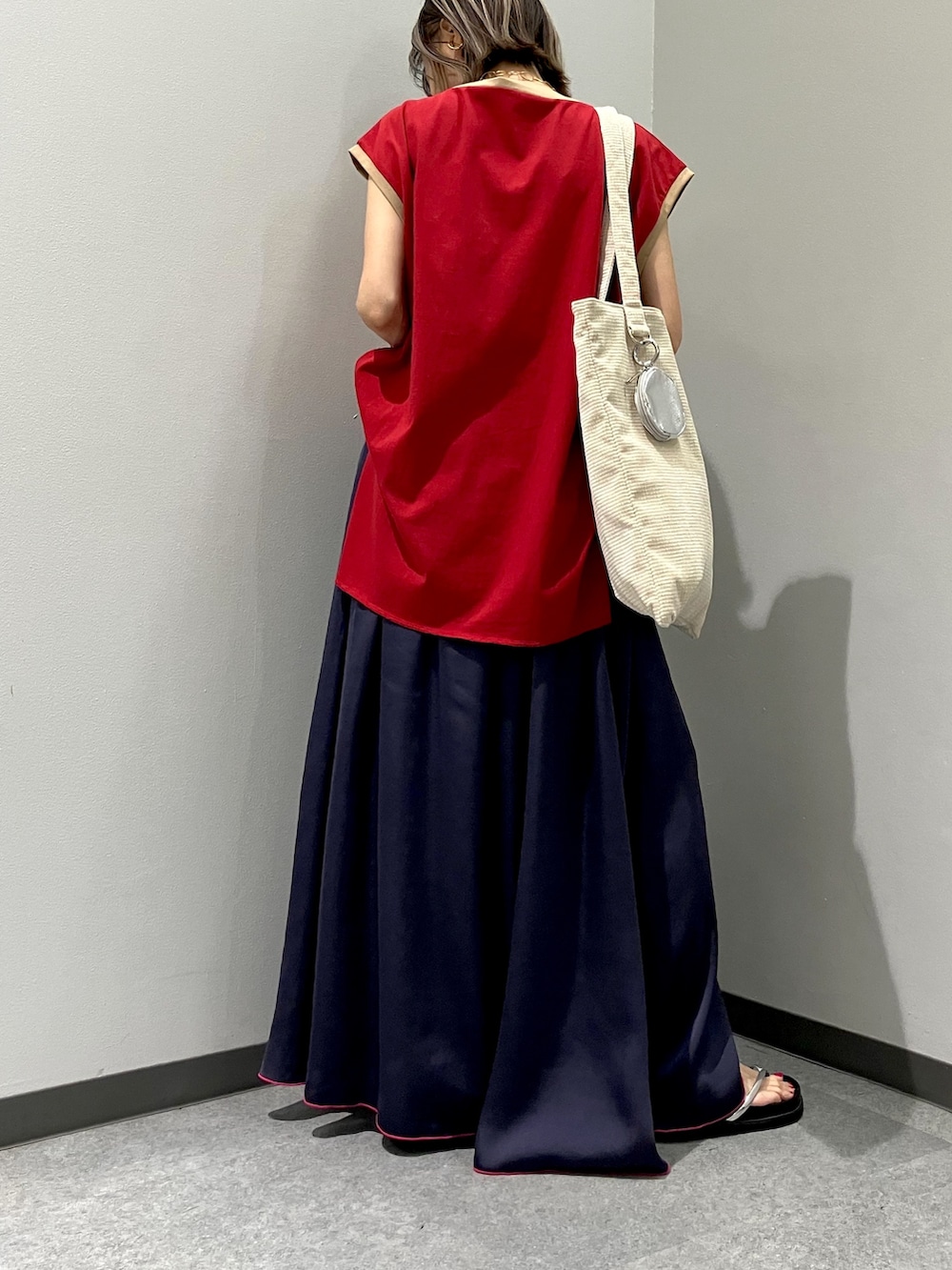 ブラック系のカーディガン/ボレロ、レッド系のTシャツ/カットソー、ブルー系のスカートを着用したレディースの秋コーディネートの3枚目の写真