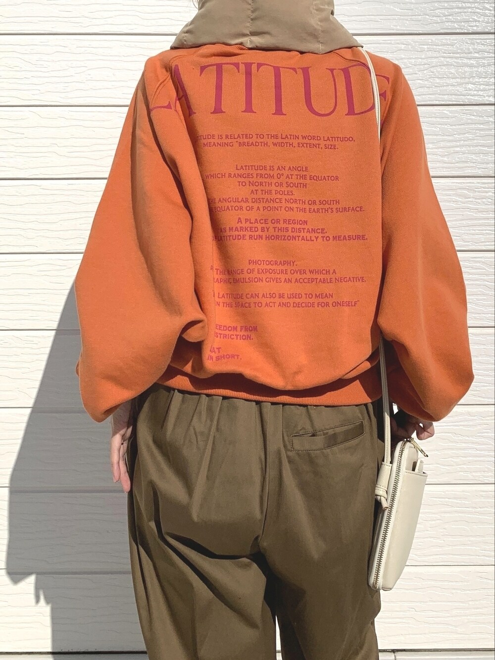 グリーン系のその他パンツ、ホワイト系のショルダーバッグ、オレンジ系のスウェットを着用したレディースの秋コーディネートの3枚目の写真