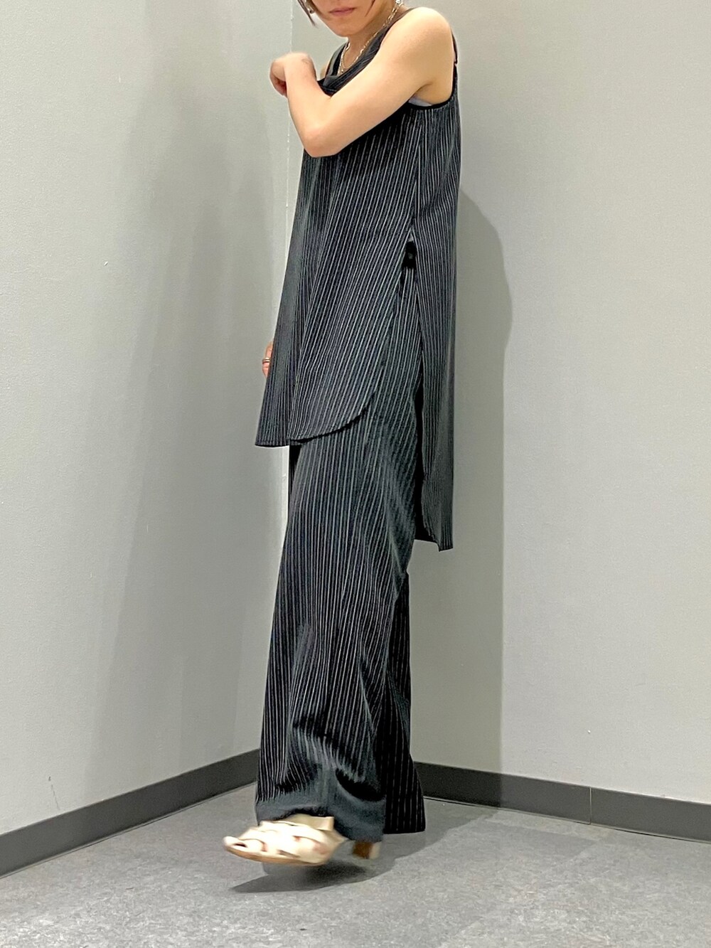 ブラック系のスラックス、ブラック系のタンクトップ、ブラック系のチュニックを着用したレディースの夏コーディネートの3枚目の写真