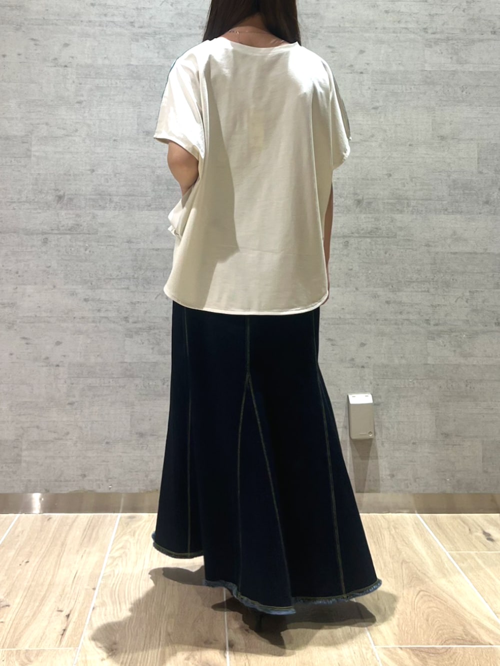 ブルー系のデニムスカート、ホワイト系のTシャツ/カットソーを着用したレディースの夏コーディネートの2枚目の写真