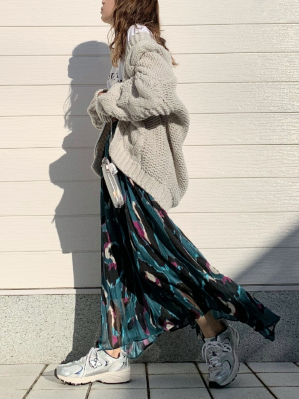 グレー系のカーディガン/ボレロ、ホワイト系のTシャツ/カットソー、グリーン系のスカートを着用したレディースの秋コーディネートの3枚目の写真