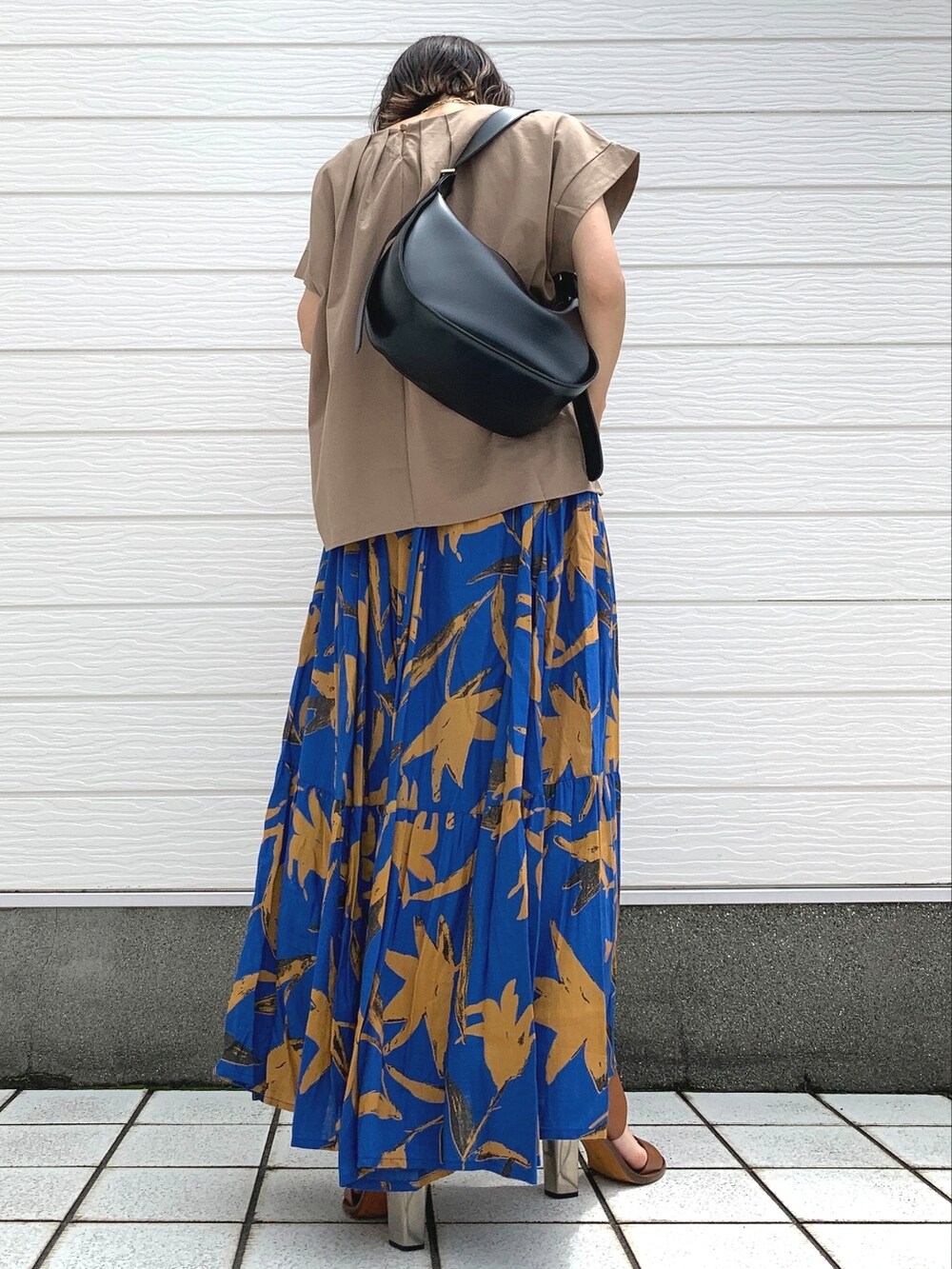 ブラウン系のサンダル、ブラック系のショルダーバッグ、ベージュ系のTシャツ/カットソーを着用したレディースの夏コーディネートの2枚目の写真