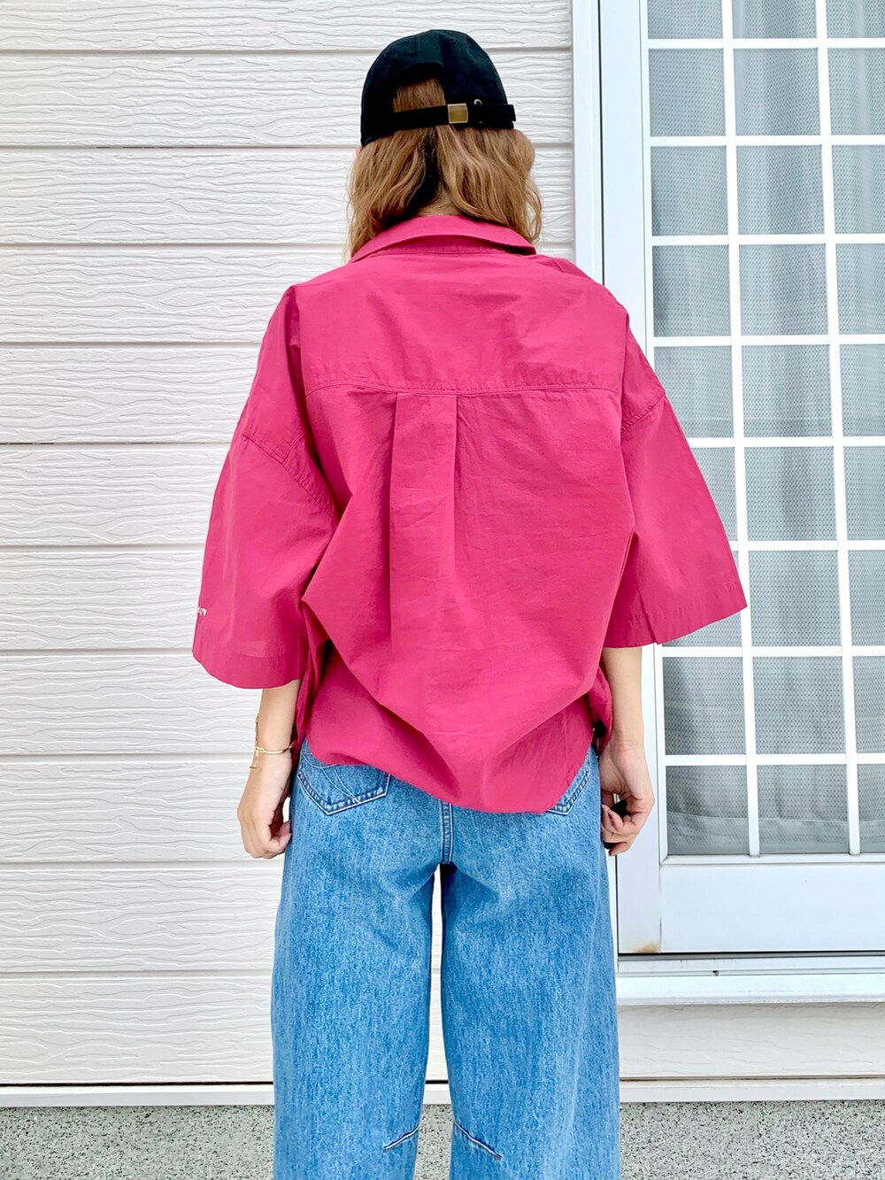 レッド系のシャツ/ブラウス、ブルー系のデニムパンツ、ゴールド系のブレスレットを着用したレディースの夏コーディネートの3枚目の写真