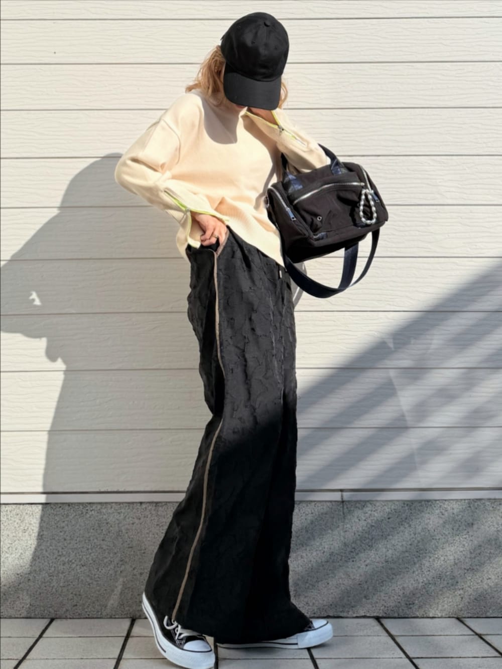 ホワイト系のニット/セーター、ブラック系のボストンバッグ、ブラック系のその他パンツを着用したレディースの冬コーディネートの2枚目の写真