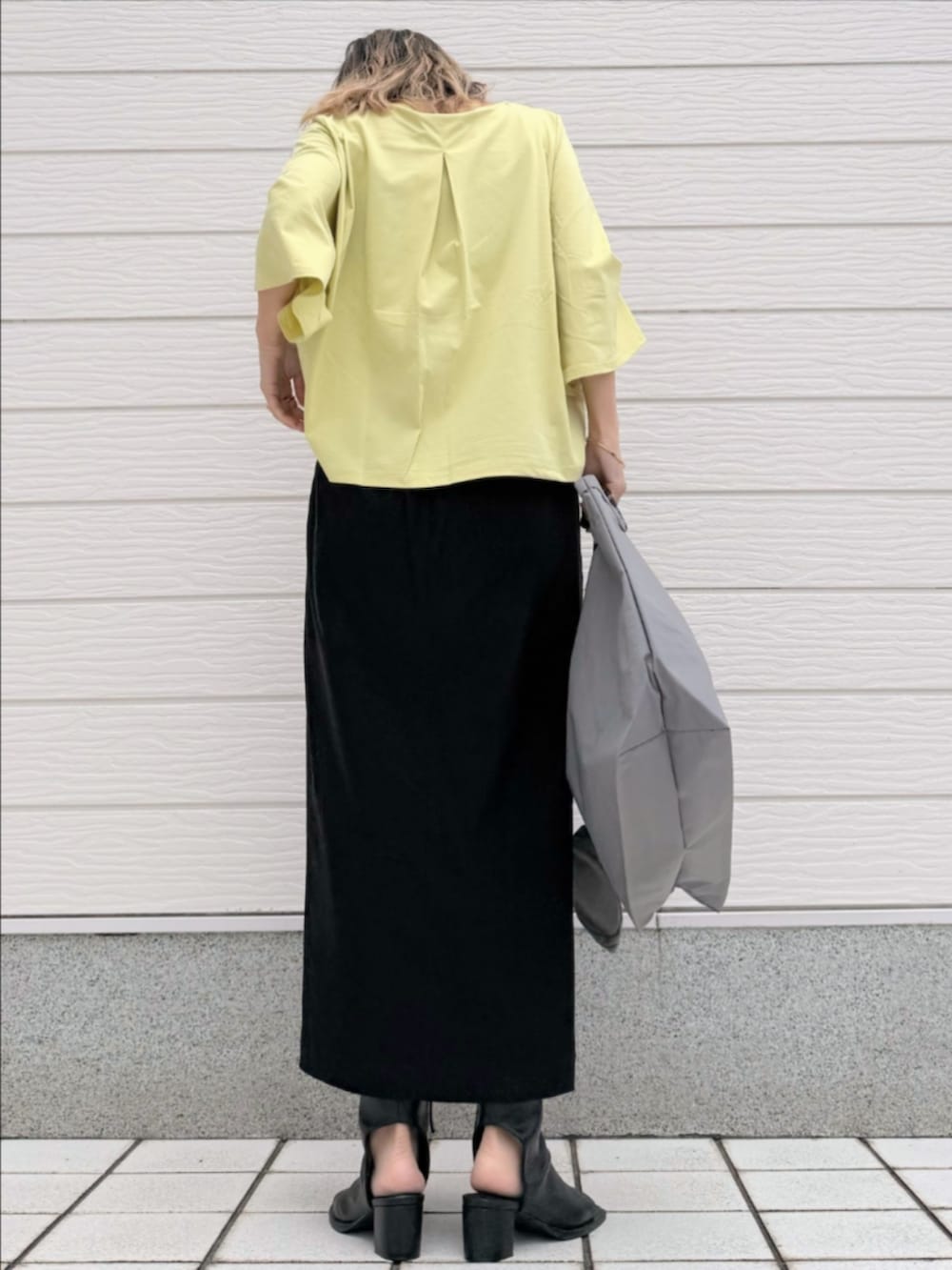 ブラック系のサンダル、ブラック系のスカート、イエロー系のTシャツ/カットソーを着用したレディースの春コーディネートの3枚目の写真
