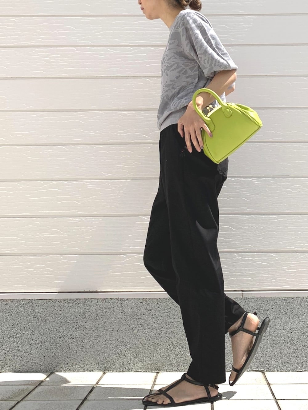 ブラック系のその他パンツ、グリーン系のショルダーバッグ、グレー系のニット/セーターを着用したレディースの春コーディネートの2枚目の写真