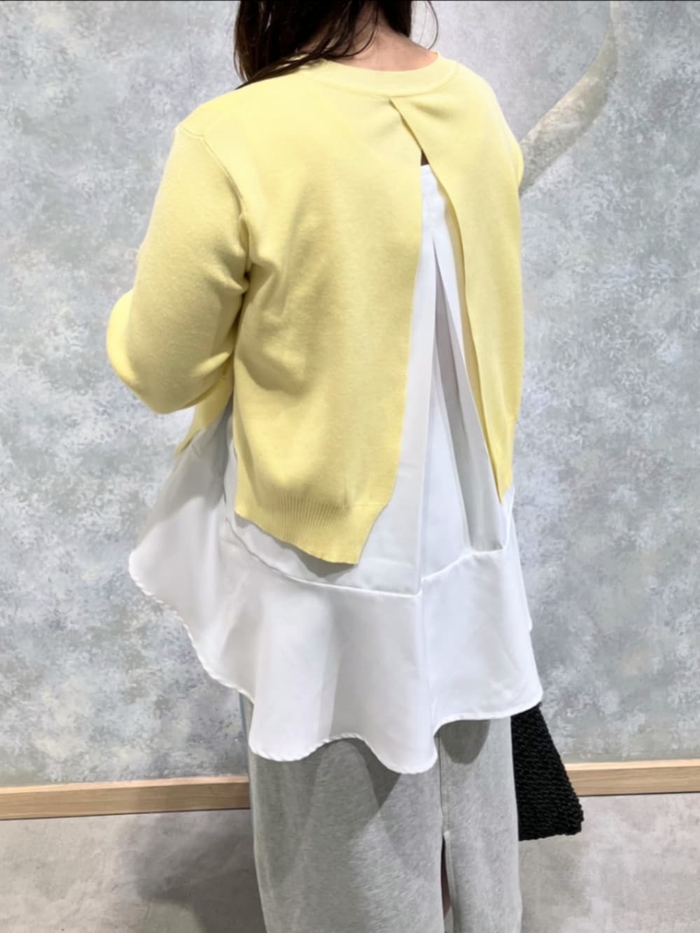 ブルー系のスカート、ブラック系のトートバッグ、イエロー系のニット/セーターを着用したレディースの冬コーディネートの5枚目の写真