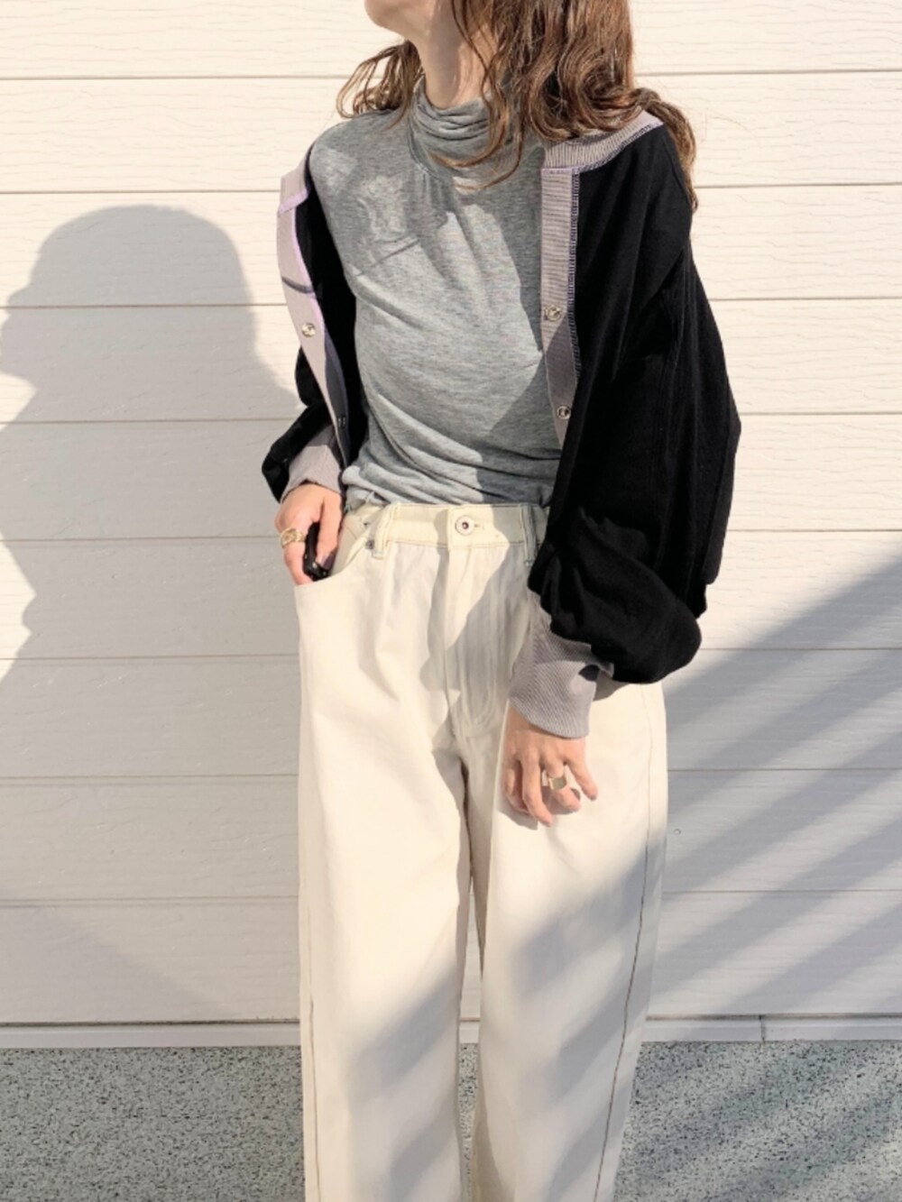 ホワイト系のデニムパンツ、グレー系のTシャツ/カットソー、ブラック系のカーディガン/ボレロを着用したレディースの秋コーディネートの3枚目の写真
