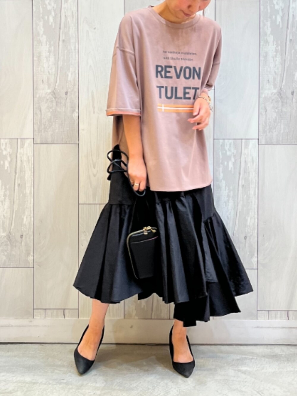 ブラック系のショルダーバッグ、ベージュ系のTシャツ/カットソーを着用したレディースの夏コーディネートの2枚目の写真