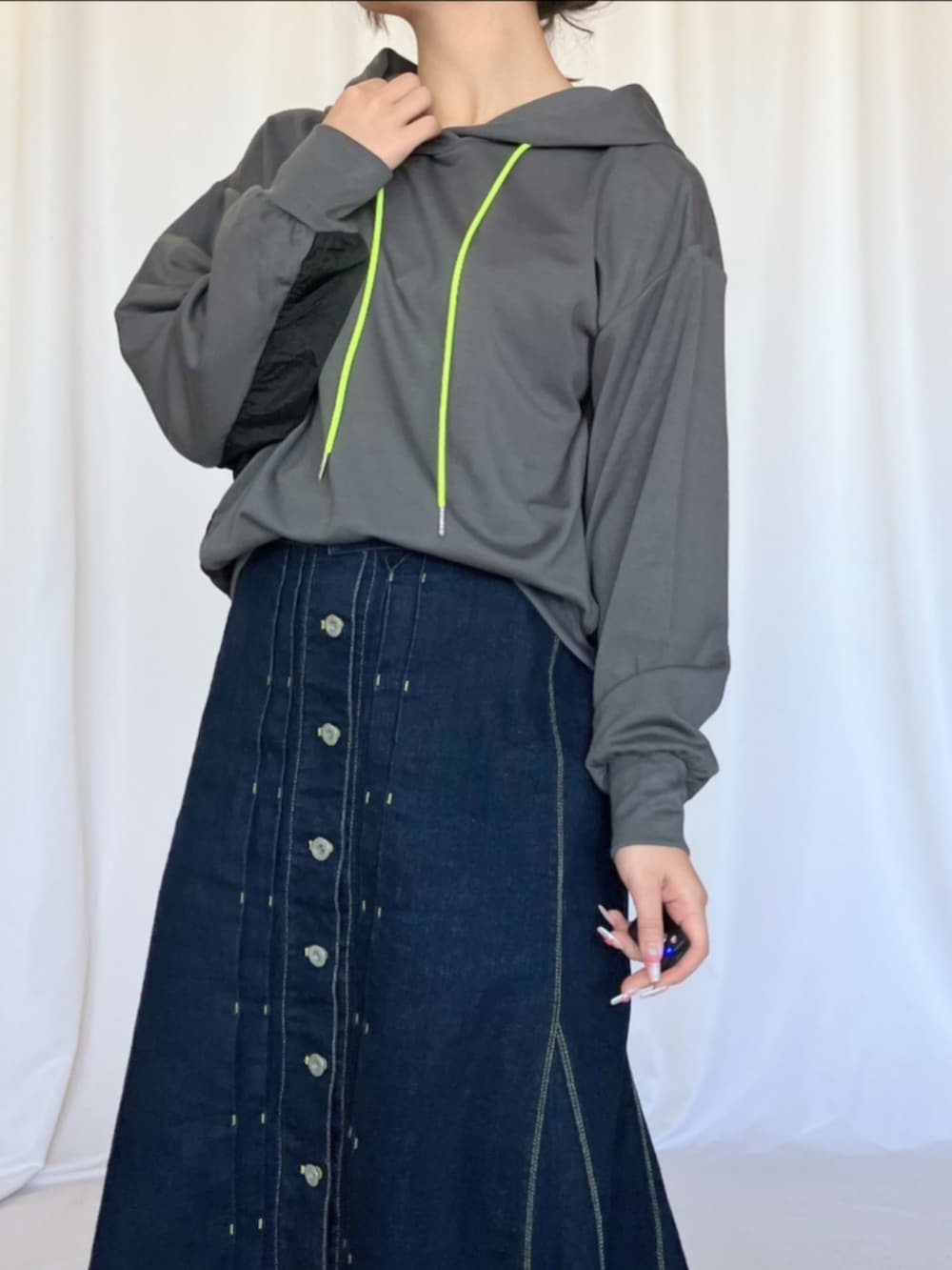 シルバー系のスニーカー、ブルー系のデニムスカート、グレー系のパーカーを着用したレディースの冬コーディネートの5枚目の写真