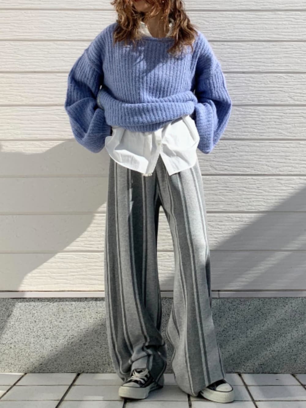 ブルー系のニット/セーター、ブラック系のスニーカー、グレー系のその他パンツを着用したレディースの冬コーディネートの3枚目の写真