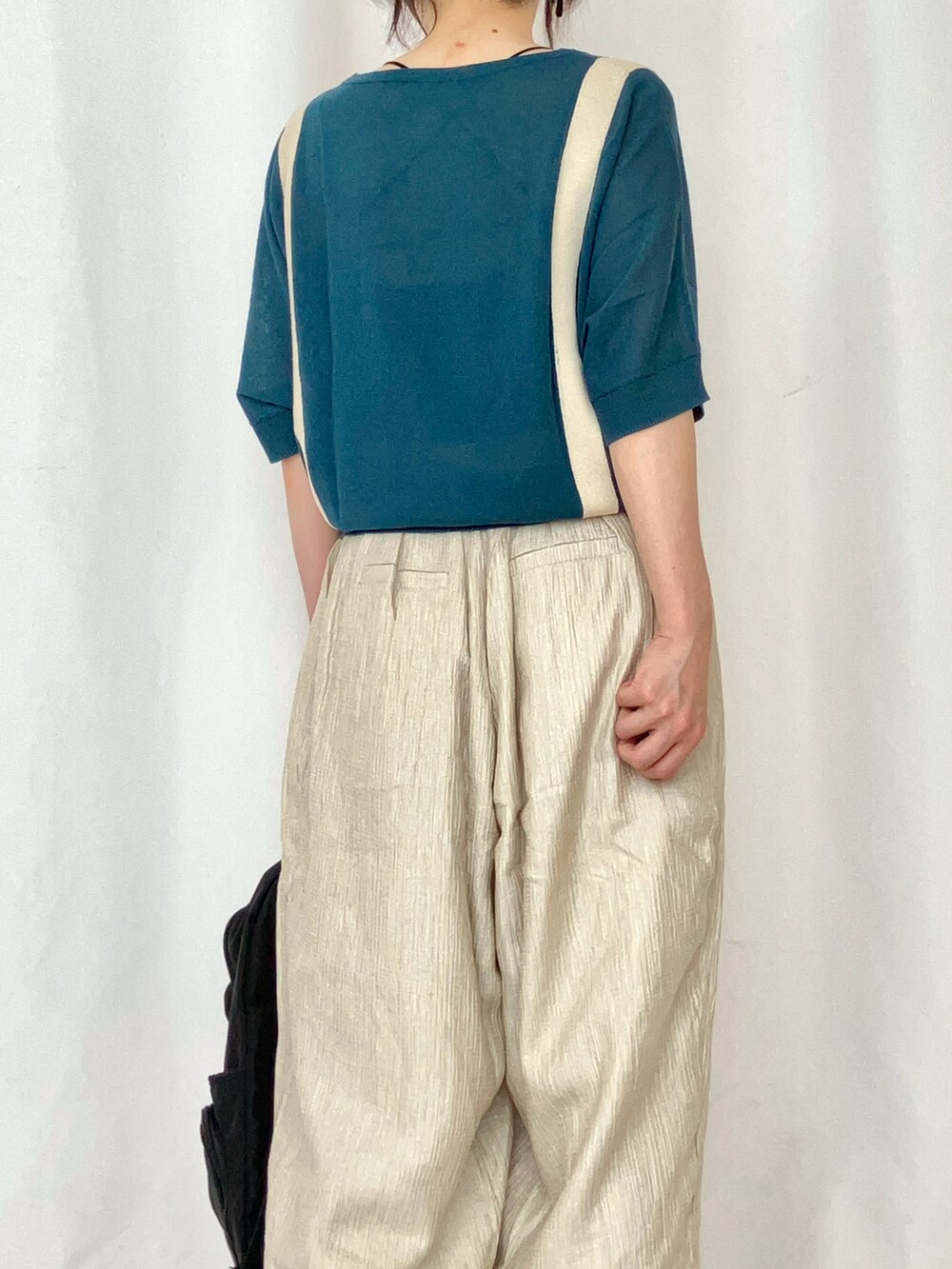 ブルー系のニット/セーター、ベージュ系のその他パンツ、グレー系のサンダルを着用したレディースの夏コーディネートの5枚目の写真