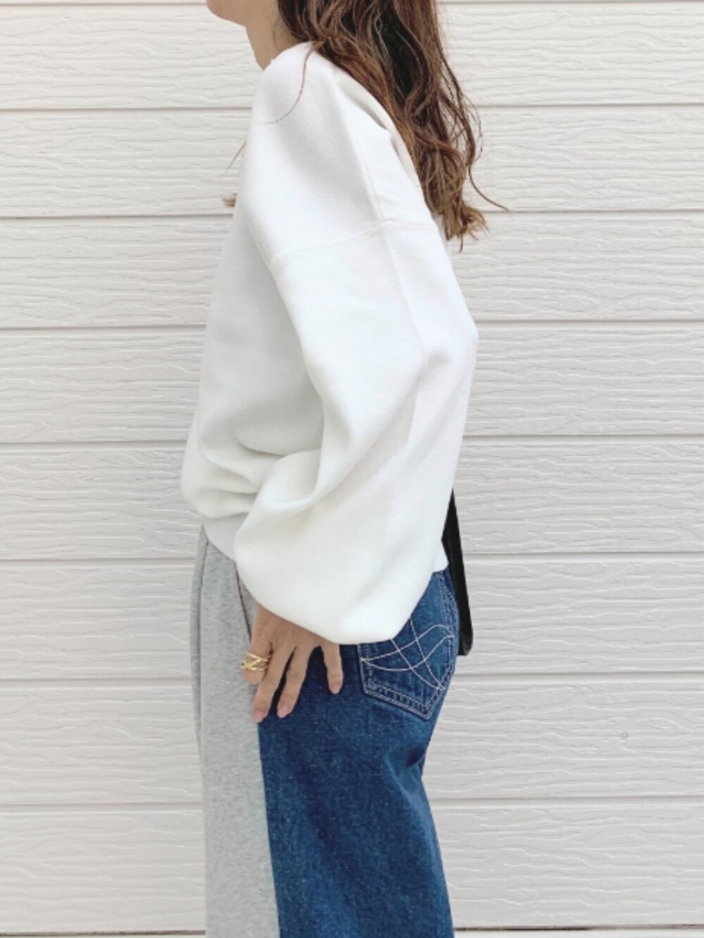 グレー系のデニムパンツ、ブラック系のショルダーバッグ、シルバー系のスニーカーを着用したレディースの冬コーディネートの4枚目の写真