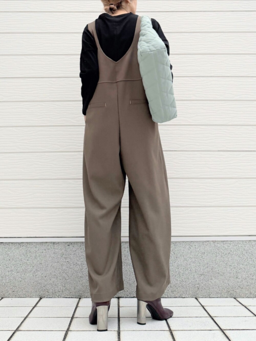 グリーン系のトートバッグ、ブラック系のTシャツ/カットソー、ブラウン系のブーツを着用したレディースの秋コーディネートの3枚目の写真