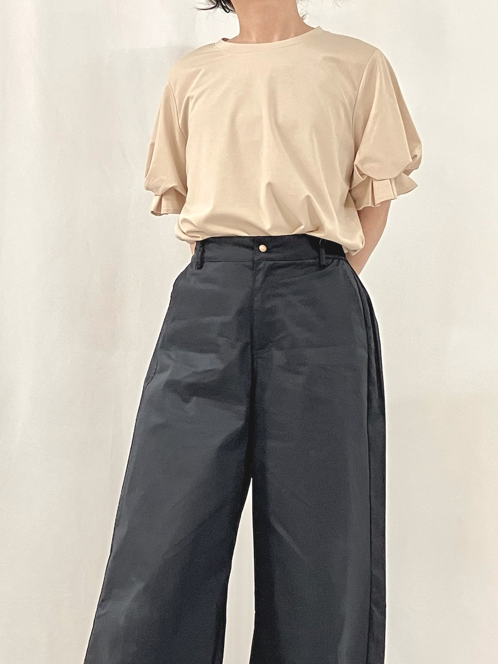 シルバー系のかごバッグ、ブラウン系のサンダル、ブルー系のスラックスを着用したレディースの夏コーディネートの4枚目の写真