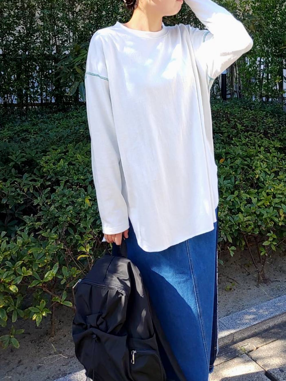 グリーン系のミリタリージャケット、ブラック系のバックパック/リュック、ホワイト系のTシャツ/カットソーを着用したレディースの秋コーディネートの3枚目の写真