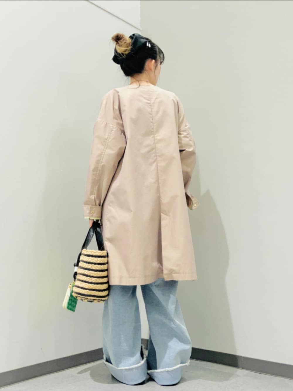 ブラック系のかごバッグ、ブルー系のデニムパンツ、ホワイト系のシャツ/ブラウスを着用したレディースの春コーディネートの2枚目の写真