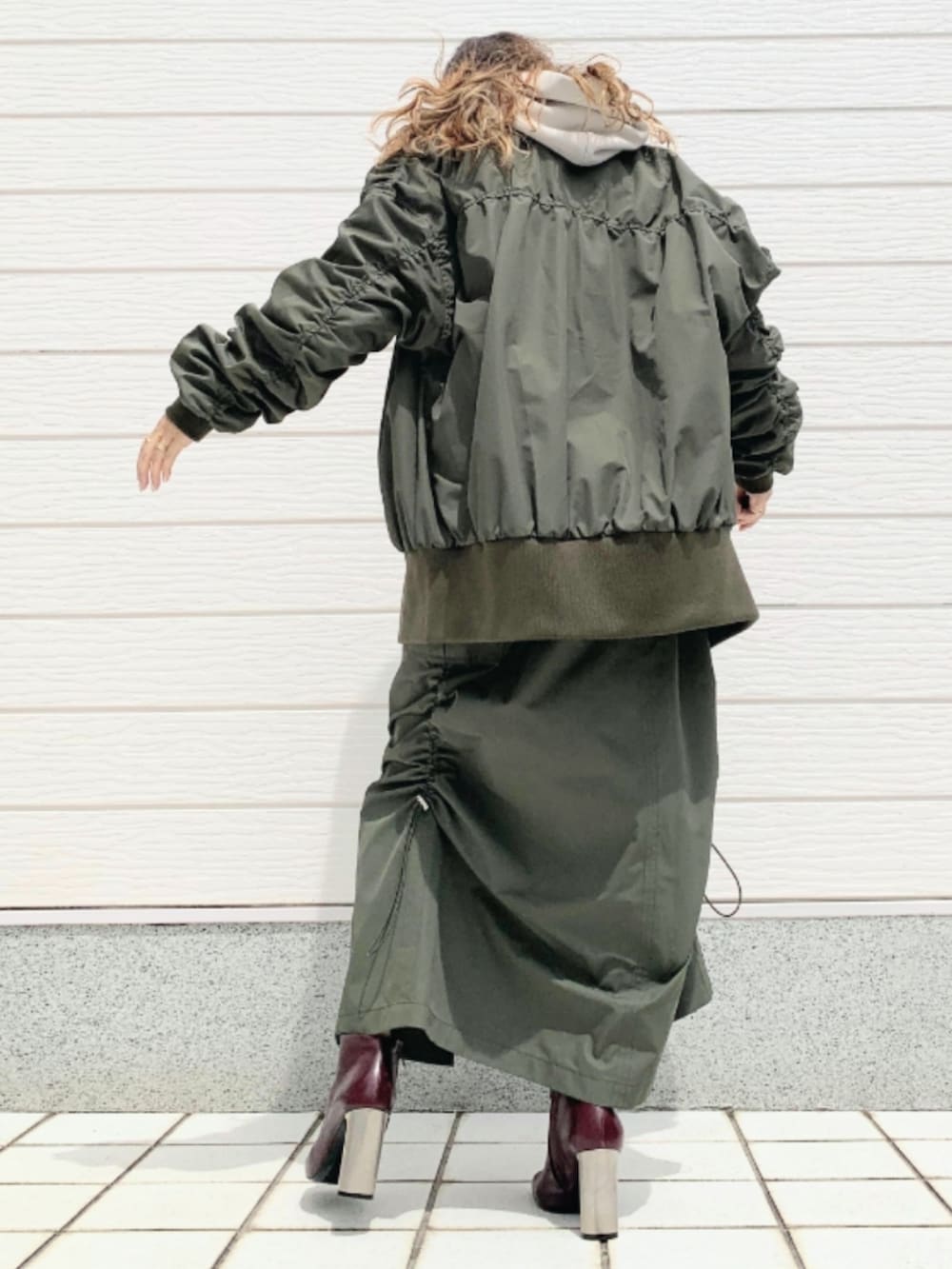 ブラウン系のブーツ、グリーン系のMA-1、グリーン系のスカートを着用したレディースの夏コーディネートの3枚目の写真