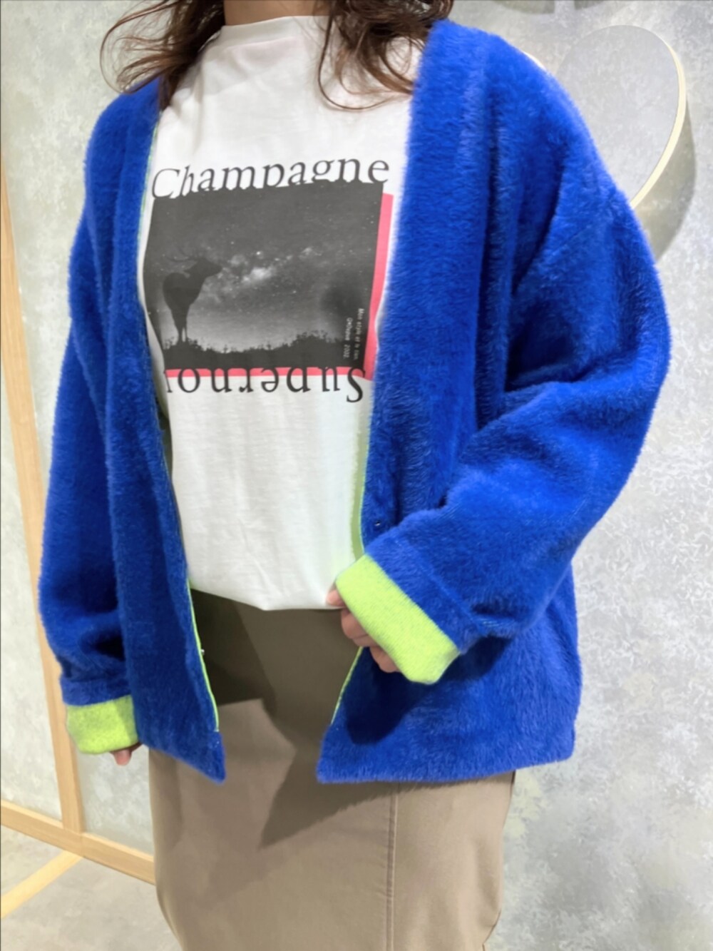 ベージュ系のスカート、ブルー系のカーディガン/ボレロ、ホワイト系のTシャツ/カットソーを着用したレディースの秋コーディネートの4枚目の写真