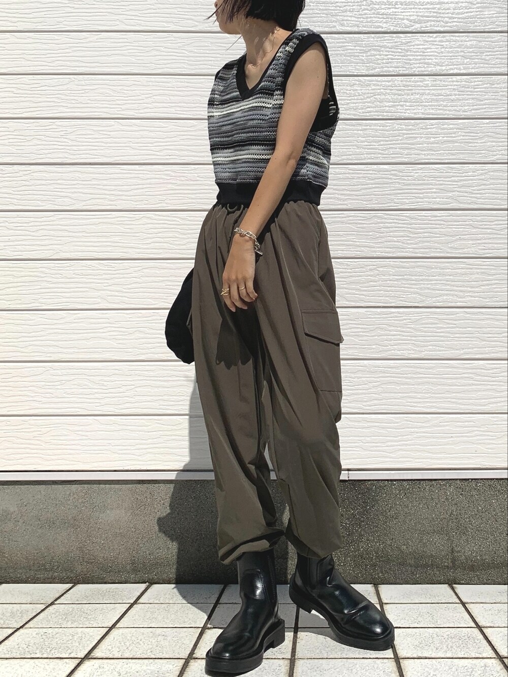 グリーン系のカーゴパンツ、ブラック系のベストを着用したレディースの夏コーディネートの2枚目の写真