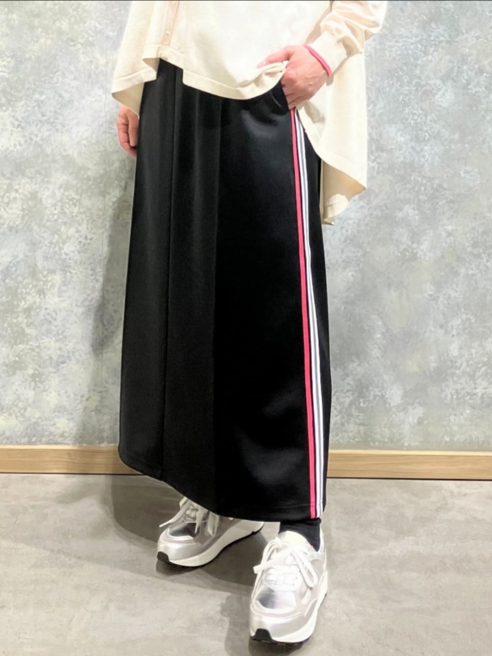 シルバー系のスニーカー、ベージュ系のカーディガン/ボレロ、ブラック系のスカートを着用したレディースの冬コーディネートの4枚目の写真