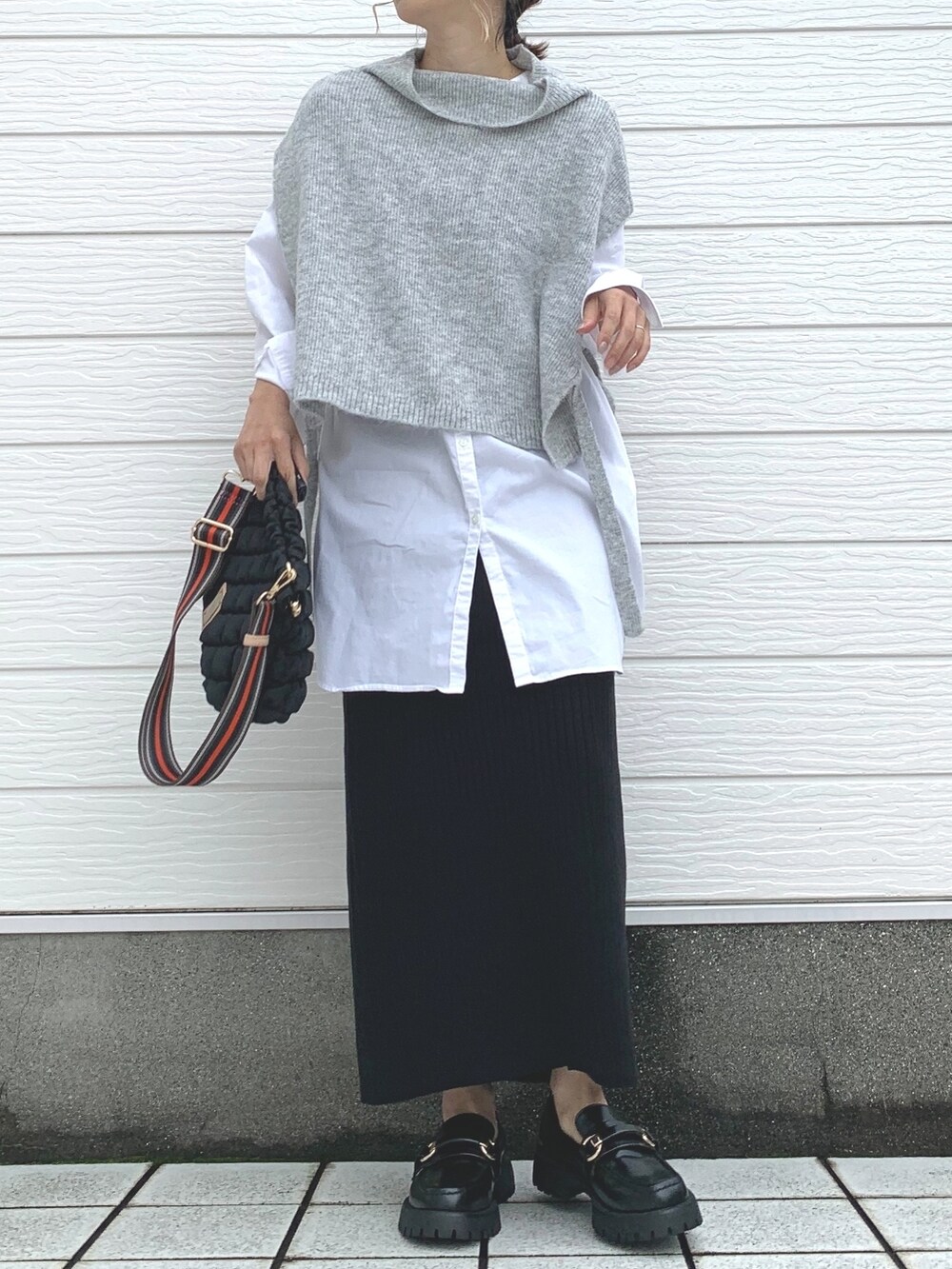 ブラック系のローファー、ブラック系のショルダーバッグ、ブラック系のベストを着用したレディースの秋コーディネートの2枚目の写真