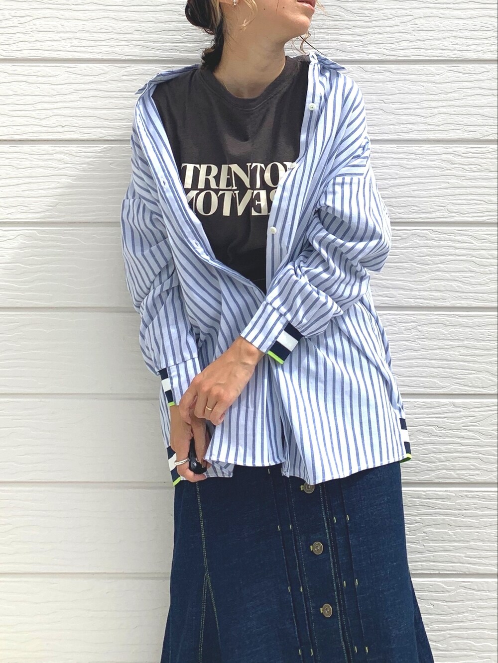 ブルー系のデニムスカート、グレー系のTシャツ/カットソー、ブラウン系のベストを着用したレディースの秋コーディネートの3枚目の写真