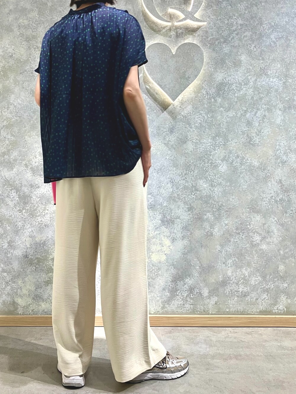 ベージュ系のその他パンツ、ブルー系のシャツ/ブラウス、ピンク系のコインケースを着用したレディースの夏コーディネートの2枚目の写真