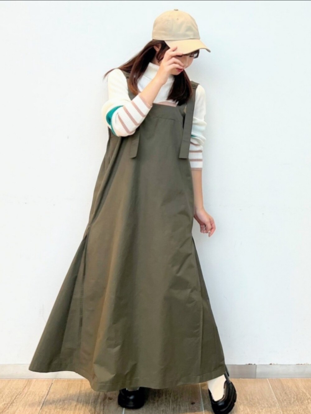 ホワイト系のブーツ、ホワイト系のニット/セーター、グリーン系のワンピースを着用したレディースの冬コーディネートの3枚目の写真