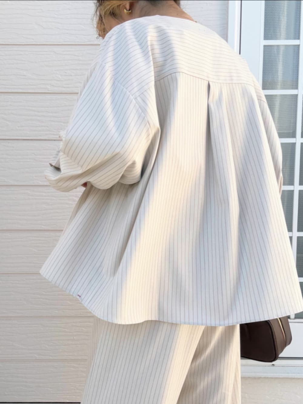 ホワイト系のTシャツ/カットソー、ベージュ系のノーカラージャケット、ベージュ系のその他パンツを着用したレディースの冬コーディネートの5枚目の写真