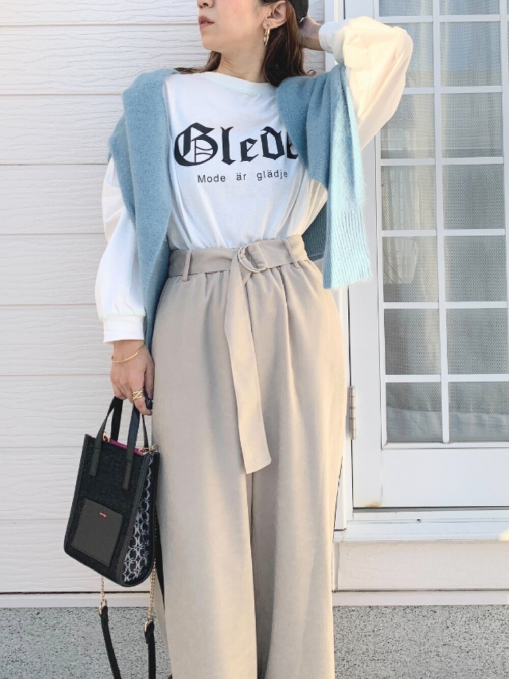ブラック系のショルダーバッグ、ホワイト系のTシャツ/カットソー、ベージュ系のその他パンツを着用したレディースの冬コーディネートの3枚目の写真